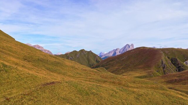 Veduta aerea mozzafiato delle Dolomiti con valli verdi, sentieri alpini e imponenti montagne rocciose sotto un cielo limpido. Un paesaggio naturale spettacolare che rappresenta la bellezza delle Alpi 