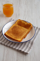 Homemade American Cinnamon Toast with Butter and Orange Juice, side view.