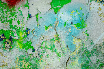 Abstract: crumbling graffiti on a city street wall. Colorful abstract background. Old, cracked, peeling paint serves as a background.