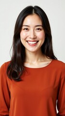 Fototapeta premium Smiling Asian woman in burnt orange sweater for marketing campaign hero image or website banner with copy space for text on clean background