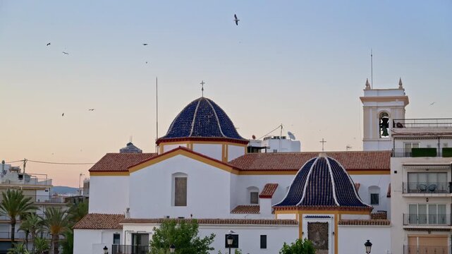 The blue tiled domes of Iglesia de San Jaime y Santa Ana in the heart of Benidorm Old Town, glowing in the evening light