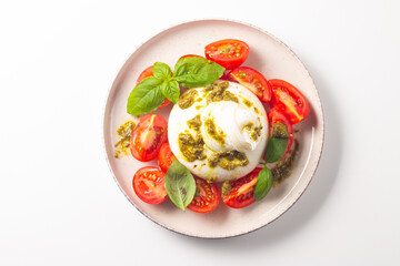 Burrata cheese caprese salad with cherry tomatoes, olive oil, pesto and seasoning. Fresh food concept. 