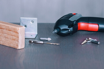 Power tools and hardware items arranged on a work surface for a home improvement project