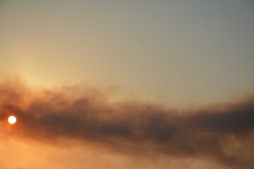 Fototapeta premium Smoke obscures the sky, the sun peeks out from behind the smoke screen