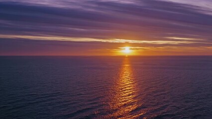 Fototapeta premium Sunset over ocean. A sunset over horizon with a calm ocean. Beautiful reflections of the sky in the evening. The sunset above the sea lifestyle.