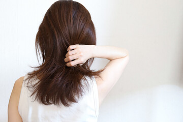 髪の毛を触る女性　ヘアケア