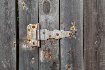 Rusty hinge on a wooden door