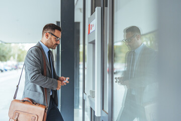 Businessman Using an Outdoor ATM Machine for Banking Transaction