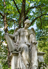sehr großer Engel sitzt auf einem Grabstein wie auf einem Stuhl Alter Südfriedhof München