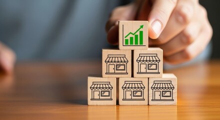 Hand placing growth chart block on top of store blocks on wooden surface view