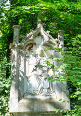 schöner sehr alter Grabstein inmitten eines Strauches Alter Südfriedhof München