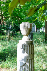 Eine Urne steht auf einer Säule mit Verzierungen Alter Südfriedhof München