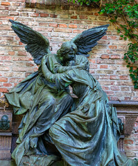Schöner großer Engel empfängt die Verstorbene im Himmel Grabstätte vor einer alten Ziegelmauer Alter Südfriedhof München