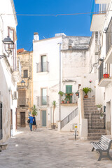 Obraz premium A shot of buildings among stone alleys and Mediterranean balconies in the historic center under a blue sky, Southern Italy. Grottaglie is a ceramics city.