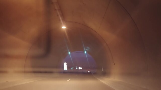 Fast drive by car through a tunnel and exiting at night
