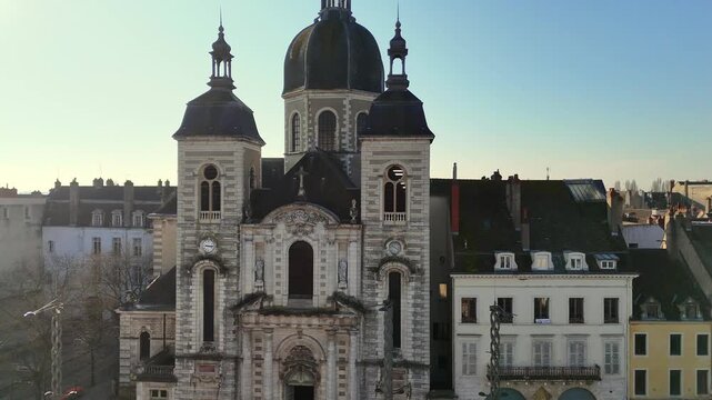 Stone church with twin towers and domed roof in Chalon sur Saone France surrounded by old town buildings under clear blue sky highlighting classical European architecture