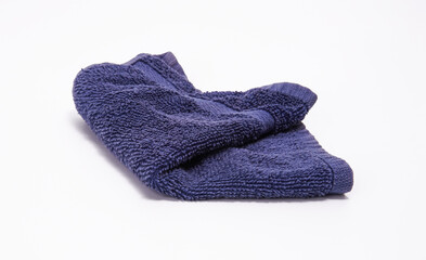 Soft, absorbent indigo blue towel, neatly folded on a pure white surface.