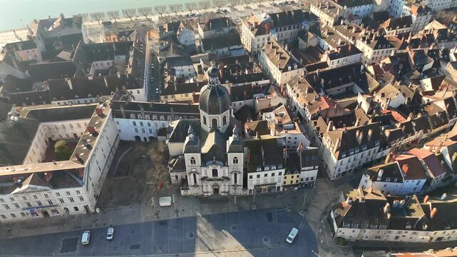 Cathedral in Chalon sur Saone France with domed roof and twin towers surrounded by old town rooftops and central square in morning sunlight near the Saone river.