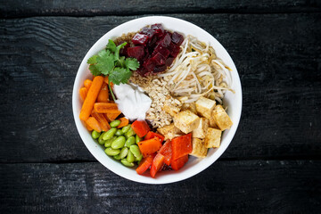 vegetable bibimbap in a white plate on a dark background