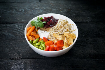 vegetable bibimbap in a white plate on a dark wooden background