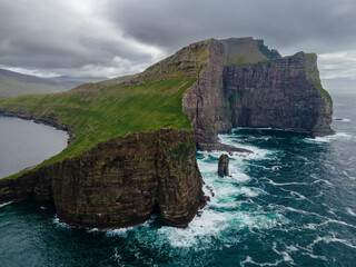 Naklejka premium Closeup of Drangarnir cliff with Tindholmur islands in the background during early morning in summer