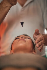 Beautiful woman recieving a reiki treatment in a health clinic. Plumb line, bob.