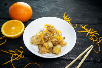 fried chicken pieces with orange zest on a white plate