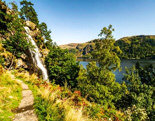 Scenic waterfall cascading down rocky cliff, tranquil lake and lush foliage