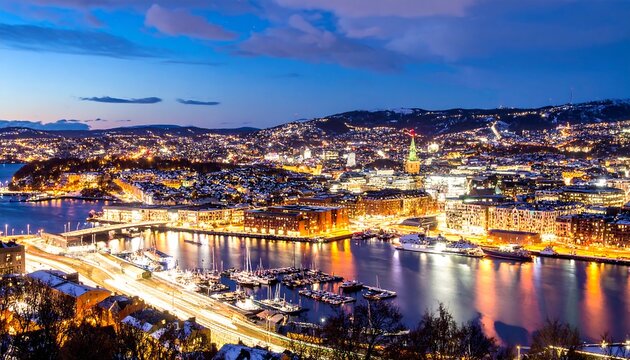 A panoramic view of a vibrant city at night, illuminated by the warm glow of countless lights reflecting on the calm water of a harbor.