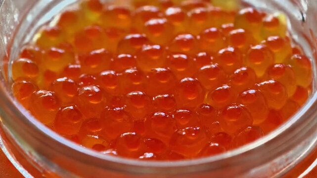 Closeup view of salmon roe, vividly showcasing its bright orange color and its round, glossy texture