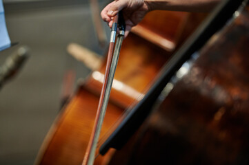 Violinist performing during a concert, captured with a focus on the bow moving across the strings, showing skill, passion, and concentration in the performance