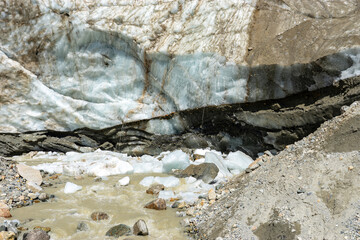 Melting glacier forming stream with rocks and ice in Georgia
