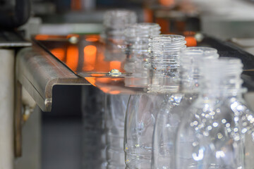 The drinking water bottles on the conveyor belt after blow mold machine.