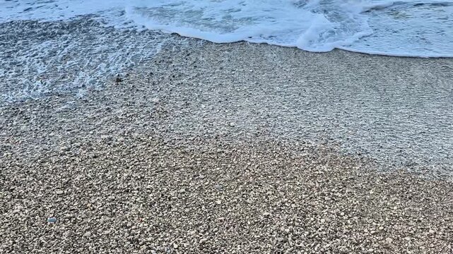 Gentle ocean waves softly caressing a beautiful sandy beach adorned with unique textures and captivating patterns