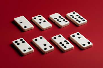 Eight dominoes arranged on a red surface with varying dot patterns shown