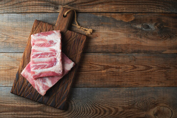 Raw pork ribs with spices, salt and rosemary on dark wooden background