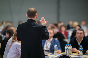 Speaker giving presentation to audience at professional seminar. Conference setting with attendees focused.