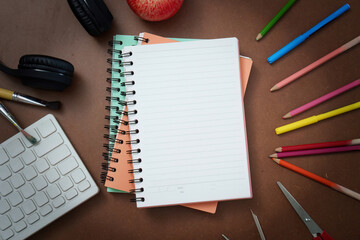 Creative Workspace: Notebooks, Colored Pencils, and Apple for Inspiration