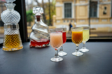 Different tinctures in stacks on a background with a decanter