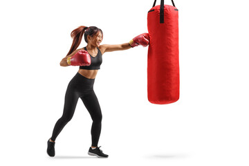Strong woman punching a bag with a boxing glove