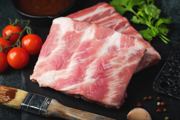 Raw meat. Raw pork ribs from the back with meat on a black background. background image