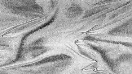 Silver foil texture with shiny metallic surface and wrinkled pattern, abstract luxury background for design and decoration.