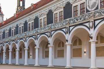 Obraz premium Stone arcade with columns and wall frescoes in an old European city.
