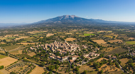 Obraz premium Aerial view of a rural town nestled at the foot of a large mountain range