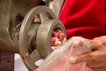 Detail of a machine mincing pork in a butcher shop in Mexico.