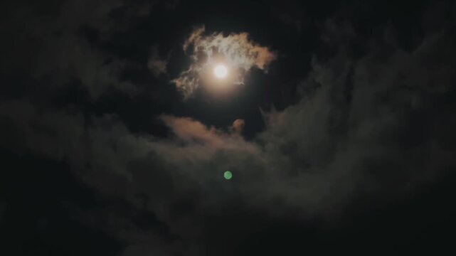 The clouds drift gently in the night sky, making the atmosphere feel calm and mysterious.