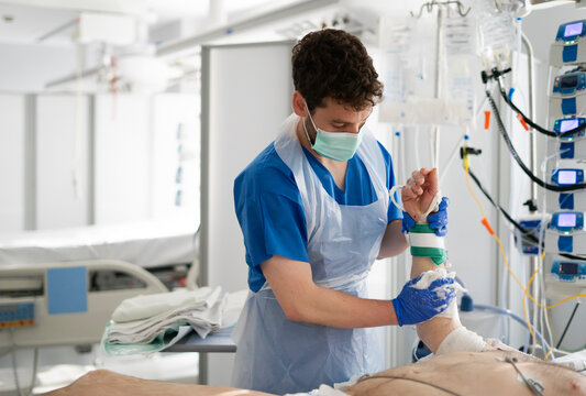 Nurse bandaging patient's arm in hospital room - Powered by Adobe