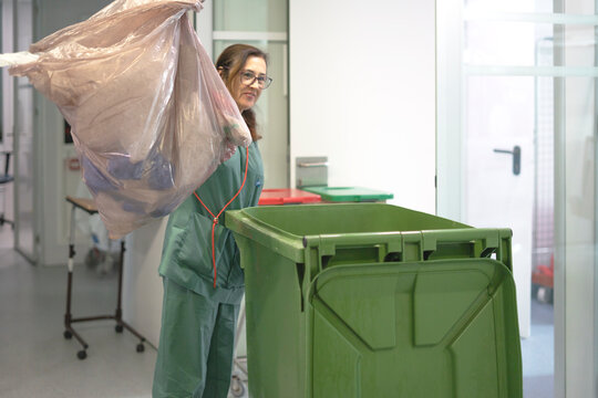 Nurse throwing away medical waste in hospital garbage bin