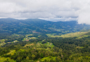 The spectacular green hills and mountain landscapes of Flesha area, a popular tourist destination in Ainaro, Timor-Leste, seen from above. A dramatic aerial journey over a remote and verdant region