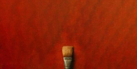 Paint brush on a red textured background with copy space.